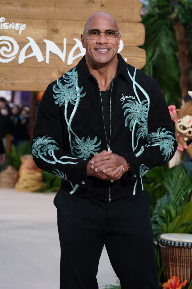 Dwayne Johnson smiling while posing for photos at a Moana premiere