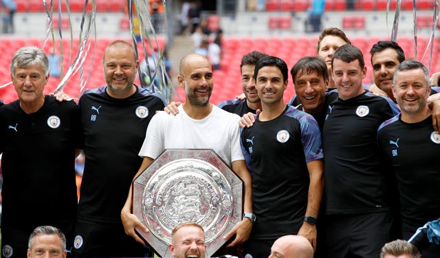 Pep Guardiola, centre, clutches the Community Shield