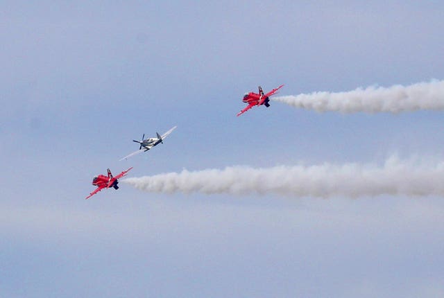 The Spitfire, flanked by two RAF Red Arrows, arrives at Goodwood Aerodrome