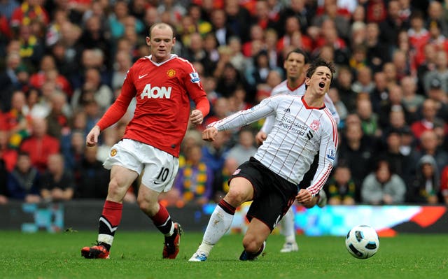 Torres goes to ground after a challenge by Manchester United's Wayne Rooney at Old Trafford in September 2010