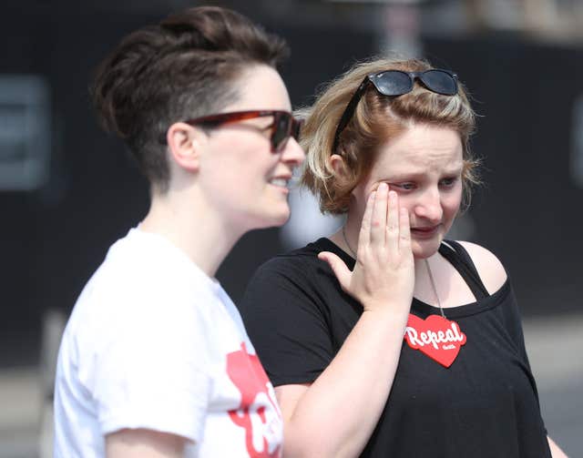 Anna McCarthy and Aoife O'Driscoll become emotional as they look at the mural (Niall Carson/PA)