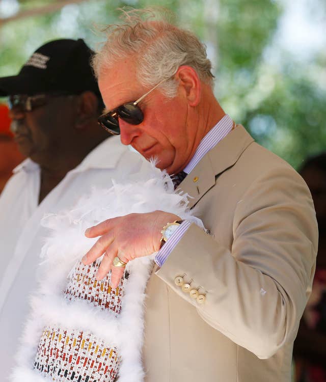 Charles puts his mulka string headband into a string basket called a bathi (Phil Noble/PA)