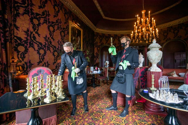 Masked hotel staff polish candlesticks