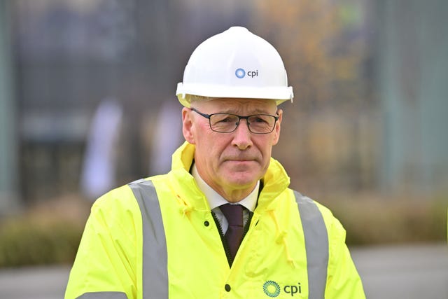 John Swinney wearing a hi-vis jacket and white hard hat