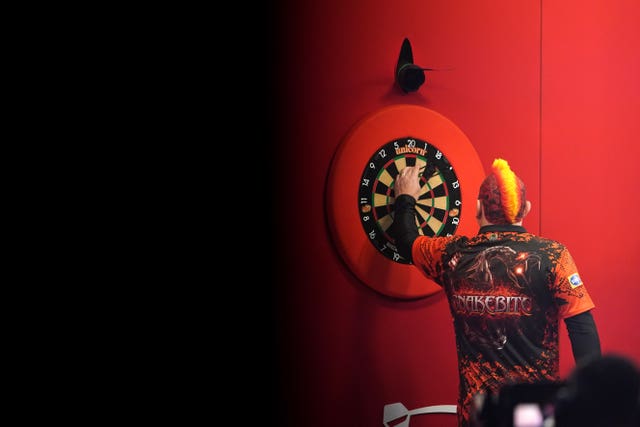 Peter Wright collects his darts during his semi-final defeat to Jonny Clayton at the Ladbrokes Masters in Milton Keynes