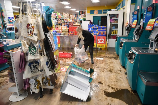 An employee cleans a Poundland shop hit by flooding in Pontypridd