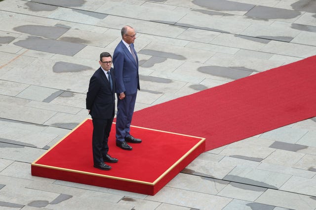 Andy Burnham, alongside German Chancellor Friedrich Merz, review a guard of honour on arrival for talks at the Chancellery in Berlin