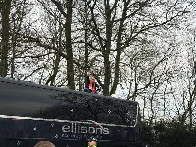 A Blackpool fans sits on the Arsenal team bus