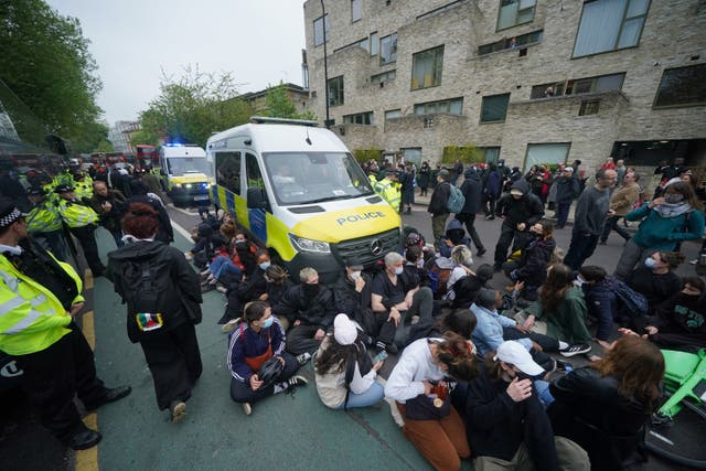 Protesters in front of a police van after they formed a blockade around the coach 