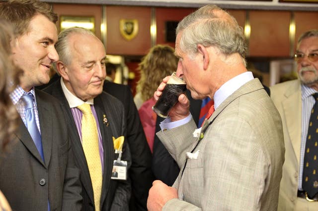 Charles sipping half a pint of Guinness in the club house at Llandovery rugby club, Llandovery, Wales