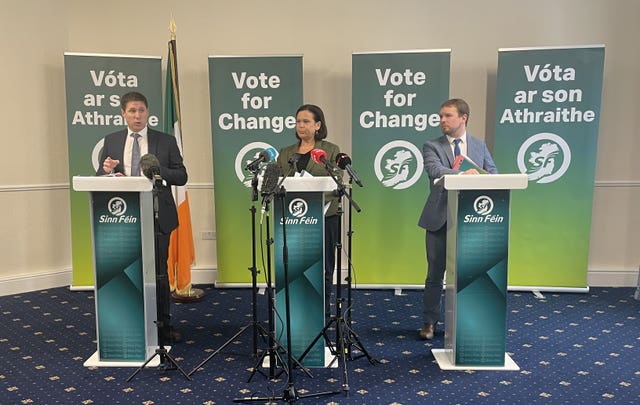 Sinn Fein’s Mary Lou McDonald, centre, speaks to the media from behind a podium