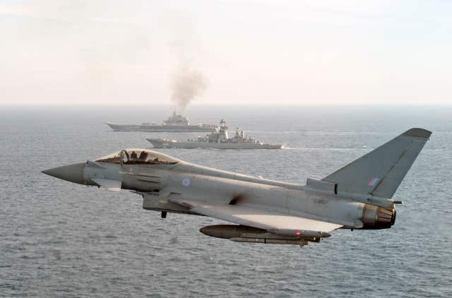 An RAF Typhoon, with the Russian Warships Petr Velikiy (centre) and the Admiral Kuznetsov (background) as they transit near to UK sovereign waters on their way back to Russia (MoD Crown Copyright/PA) 