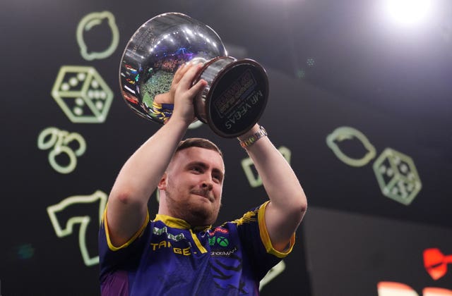 Luke Littler lifts the trophy after winning the Grand Slam of Darts