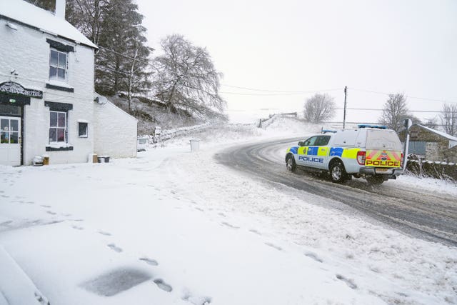 A police surrounded by snow driving on a road in Middleton-in-Teesdale, County Durham