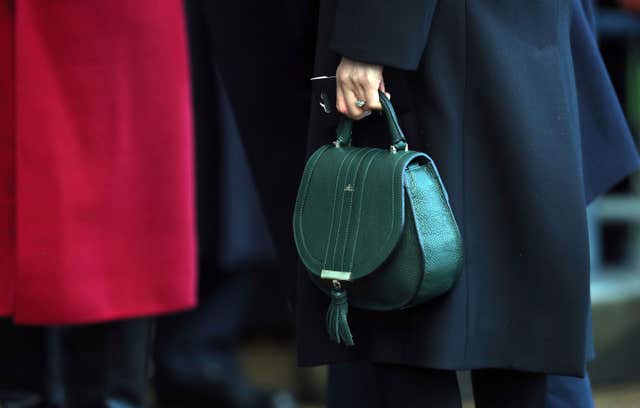 Meghan Markle holding her handbag on a walkabout during a visit to Cardiff Castle (PA)