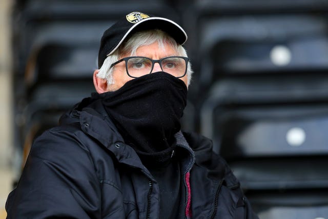A Notts County fan covers his mouth with a scarf 