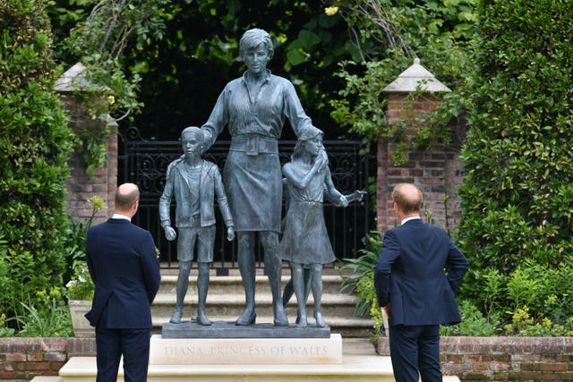 The then-Duke of Cambridge and Duke of Sussex look at the statue they commissioned of their mother in the Sunken Garden at Kensington Palace in 2021