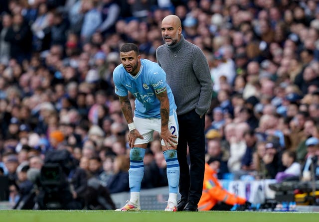 Manchester City manager Pep Guardiola speaks with Kyle Walker during a game