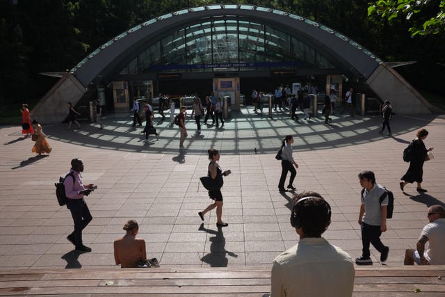 Commuters walking in the sunshine outside a station