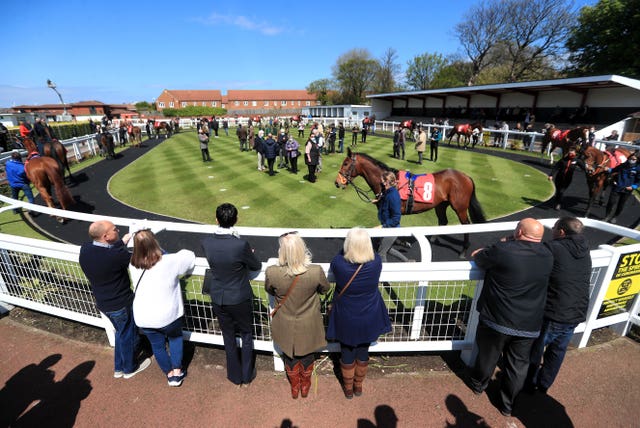 Racegoers inspect the parade ring at Redcar Racecourse 