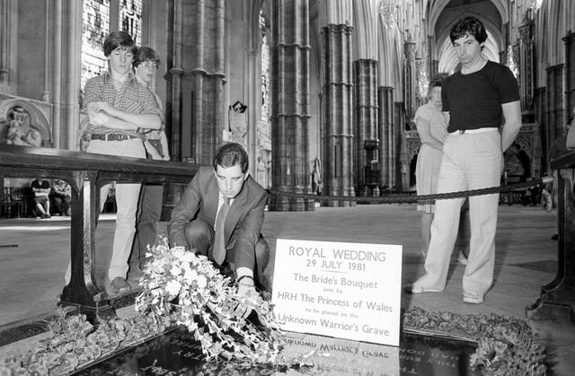 A registrar of Westminster Abbey gently lowering the Princess of Wales's bridal bouquet onto the Tomb of the Unknown Warrior (PA)