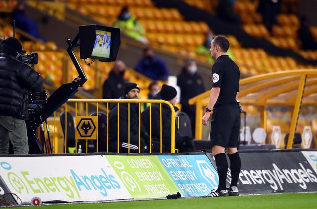 Match referee Stuart Attwell checks the pitch side monitor for a VAR penalty decision at Molineux