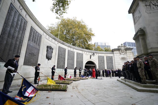 People observe a two-minute silence to remember the war dead on Armistice Day at the WWI memorial, Guildhall Square, in Portsmouth