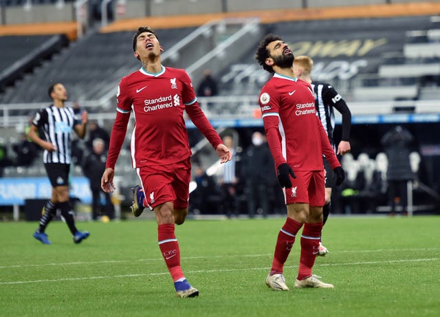 Roberto Firmino and Mohamed Salah react to a missed chance