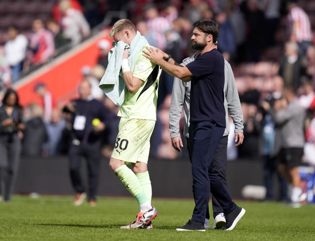 Southampton manager Russell Martin consoles goalkeeper Aaron Ramsdale after the defeat against Manchester United and wipes his eyes with a green towel. 