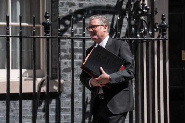 Sir Keir Starmer walking along Downing Street carrying a folder