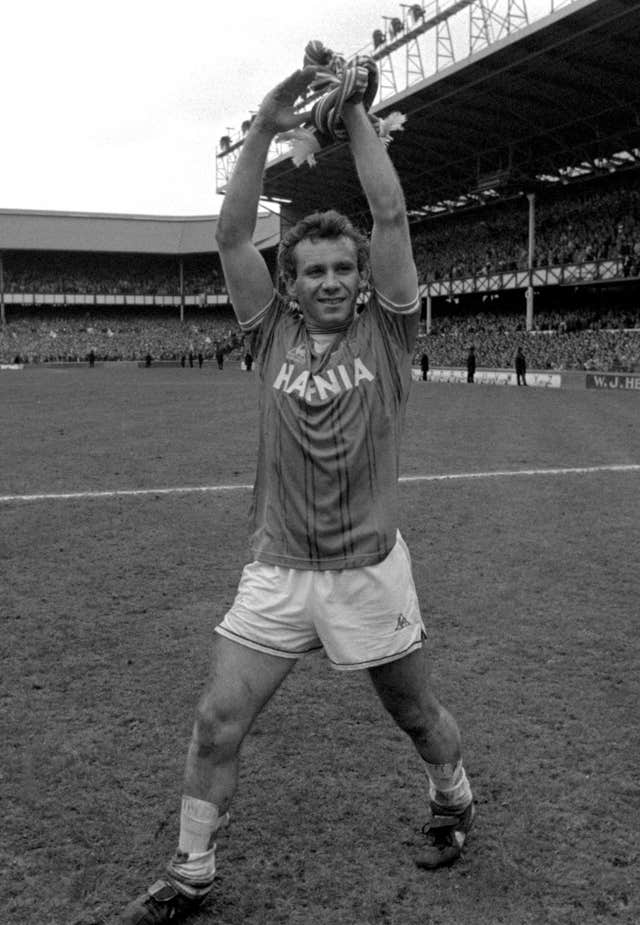 Peter Reid holds the Division One championship trophy above his head