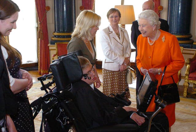 The Queen meets Professor Stephen Hawking and Lucy Hawking in the Music Room at Buckingham Palace (PA)