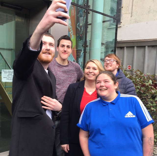 Karen Bradley with young people involved with Youth Action NI during a visit to its offices in Belfast 