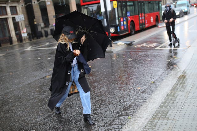 A woman walks through the rain in Westminster