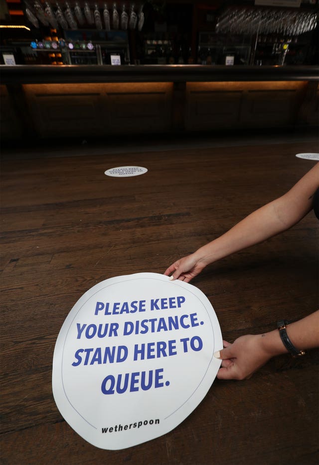 Social distancing signs on the floor of Wetherspoons pub The Mossy Well in Muswell Hill, London
