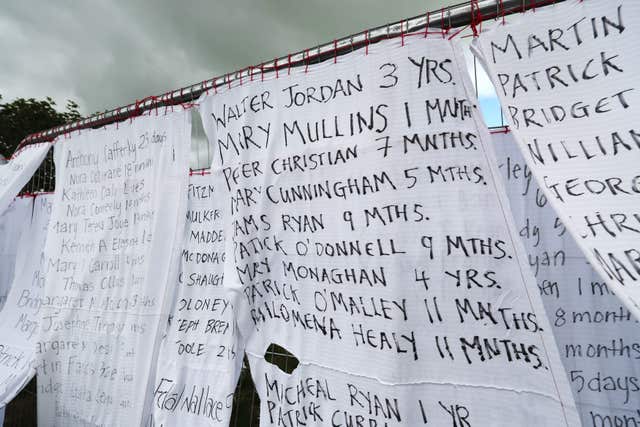 Bed sheets with the names of hundreds of dead children draped on the gates of a mass burial site at Tuam