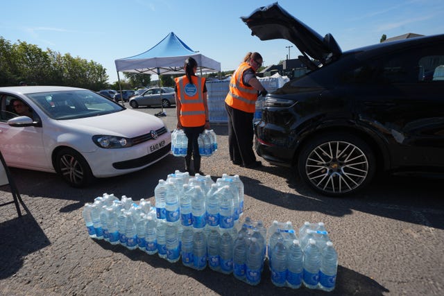 Thames Water personnel handing out bottled water to residents at Roding Sports Centre in Chigwell, Essex