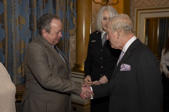 Charles greeting train driver Andrew Johnson at Buckingham Palace