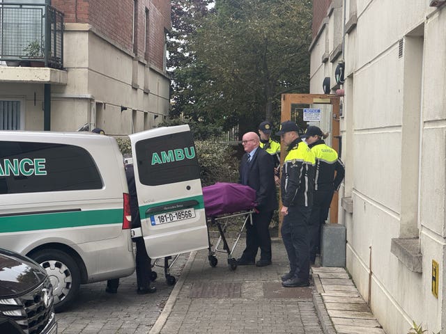 A body being moved into an ambulance