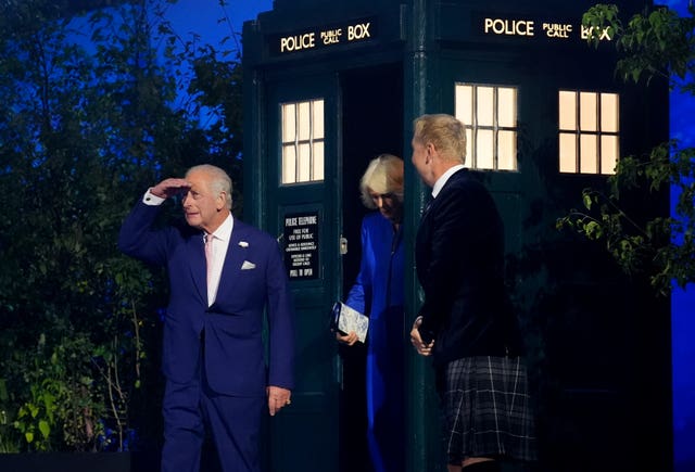 Charles stepping out of the Tardis with Camilla and Sir Chris Hoy