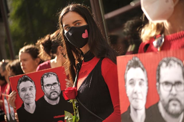 People standing in a line, holding posters