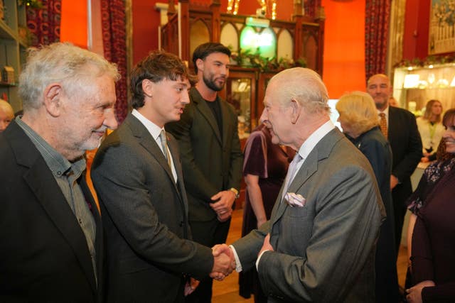 The King shakes hands with Lewis Leigh (second left) during a visit to Cyfarthfa Castle in Merthyr Tydfil, South Wales