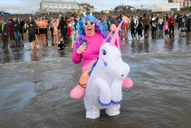 People take part in the Barry Island New Year’s Day swim in Barry, Vale of Glamorgan, Wales