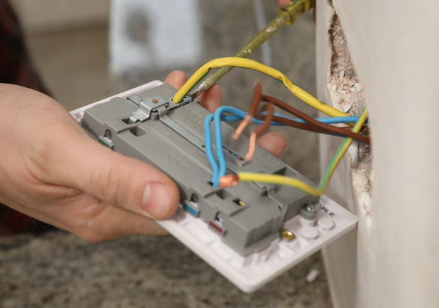 Richard Burr fitting a USB plug into a wall