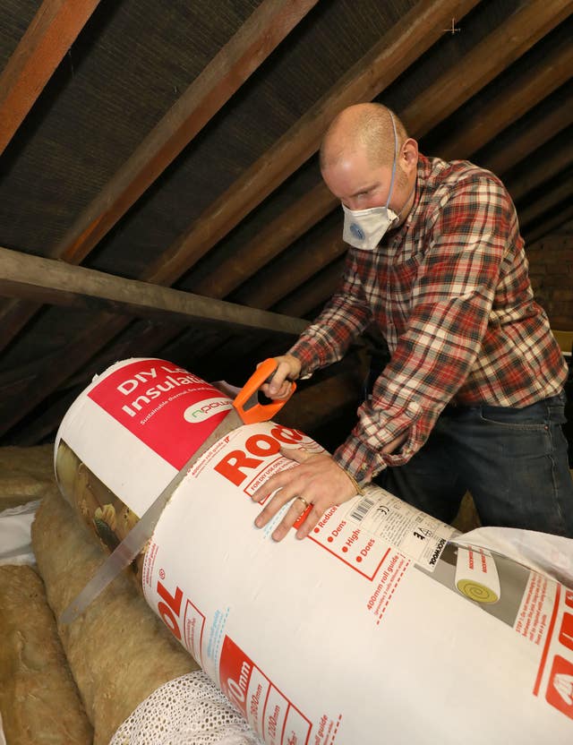 Richard Burr installing loft insulation (Philip Toscano/PA)