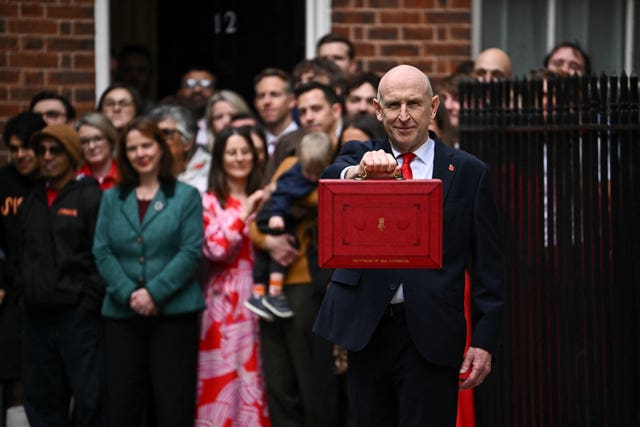 Chancellor John Healey poses with the red Budget dispatch case