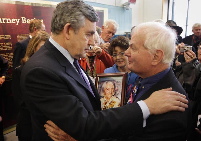 Prime Minister Gordon Brown meets with grown up child migrant John Hennessy as he holds a photograph of his mother May Mary Hennessy at Portcullis House, central London where he apologised for Britain’s role in sending thousands of children to Australia and New Zealand