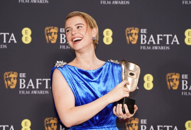 Jessie Buckley laughs as she poses with her award