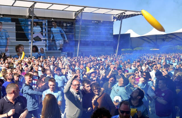 Manchester City fans celebrate outside the Etihad Stadium