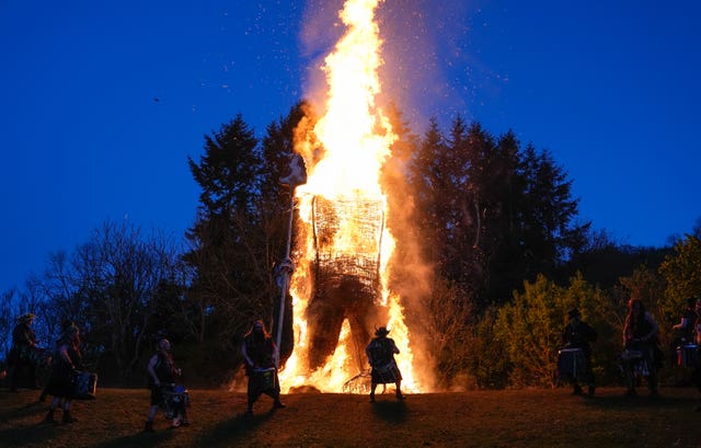 Members of the Pentacle Drummers perform in front of a burning wicker man during the Beltain Celtic Fire Festival at Butser Ancient Farm, near Waterlooville, Hampshire 